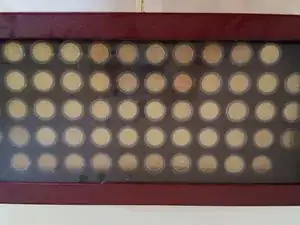 Réparation du verre d'une vitrine pour pièces de monnaie.