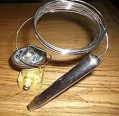 une sonde de température : le gaz contenu dans un « bulbe » se dilate sous lorsque la température augmente et agit sur une membrane reliée à un interrupteur électrique