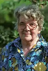 Le feuillage en arrière-plan se mélange aux cheveux : pour le rendre flou, ouvrir le diaphragme et éloigner le modèle du fond.