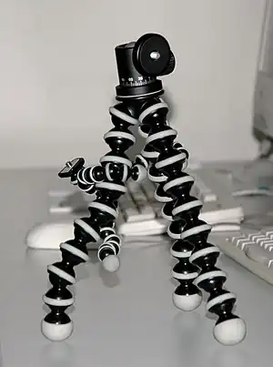 GorillaPod, deux modèles. Le GorillaPod  de Joby est formé de trois bras articulés qui peuvent s'enrouler à volonté autour des objets les plus divers. Le dernier modèle possède à l'extrémité des pieds trois puissants aimants permanents au néodyme qui permettent de l'accrocher à des objets en fer ou acier tels que des grilles, des carrosseries d'automobiles, des poteaux, des bidons, etc. Cet accessoire est de petite taille et très léger, il ne convient que pour des appareils compacts, pas pour des reflex qui sont beaucoup plus lourds et nécessitent le modèle de plus forte taille.