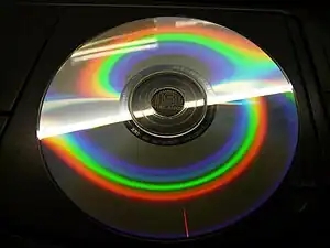 La gravure d'un cédérom constitue un réseau capable de décomposer la lumière qu'il reçoit. On visualise ici par un moyen très simple le spectre d'un tube fluorescent, ce qui permet de constater l'absence de certaines radiations entre les diverses bandes colorées. Les jaunes, en particulier, manquent totalement.