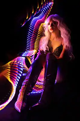 Le portrait en pied de la jeune femme est associé à des motifs réalisés à l'aide d'un ensemble de diodes électroluminescentes