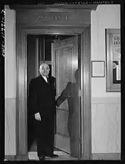 Postmaster Robert Pautz chatting with two friends in the post office