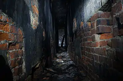 Le puits Arthur-de-Buyer à Magny-Danigon (Haute-Saône), sous-sol du bâtiment des machines ; le caractère sinistre de ce lieu abandonné est renforcé par la mise en lumière de certaines parties seulement des parois et du sol.