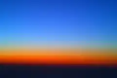 Diffusion de Rayleigh juste après le coucher du soleil, photographiée avec un petit téléobjectif (50 mm sur un capteur de 24x16 mm). Le ciel encore éclairé diffuse une lumière bleu foncé tandis que la lumière qui arrive plus directement a perdu ses radiations bleues et forme une large zone rougeâtre.